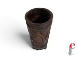 a small wooden cup with carvings on it on a white surface