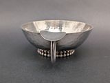 a close up of a silver bowl with a spoon in it