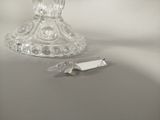 a glass candle holder and a knife on a table