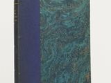 an old book with a blue cover sitting on top of a white table