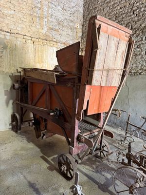 une vieille charrette en bois avec un siège en bois dans une pièce