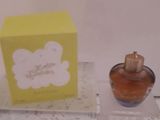 un petit flacon de parfum posé à côté d'une boîte