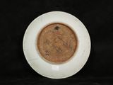 a white plate with a brown rim on a black background