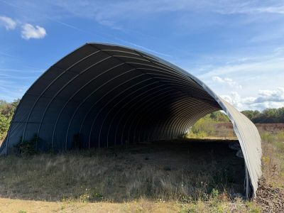 a large metal structure sitting in the middle of a field