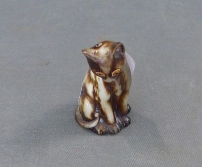 une petite figurine représentant un chat assis sur une table
