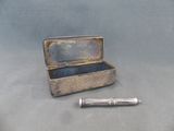 une petite boîte en métal contenant un stylo