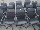 des rangées de chaises de bureau noires ornées d'étiquettes orange, dans un parking