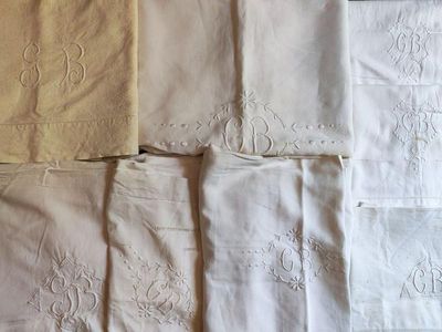 de nombreux types de linge de lit blanc sur un lit