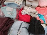 a pile of baby clothes and other items on a table