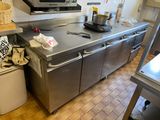 une grande cuisine en inox équipée d'une cuisinière et d'un évier
