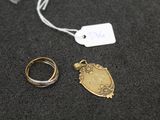 two gold rings and a silver ring on a black surface