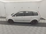 a small white car parked in a room with checkered floor