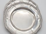 a close up of a silver plate on a white surface