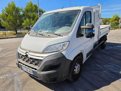 Le camion blanc est garé sur le parking près des arbres.