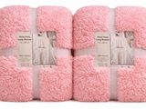 quatre serviettes roses empilées les unes sur les autres sur une surface blanche