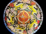 a colorful plate with designs on it on a black background