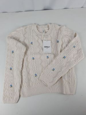 the sweater is white and has blue buttons on it