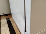 a white refrigerator sitting on a pallet in a room