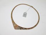 un collier muni d'une étiquette, posé sur une surface blanche