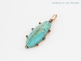 a close up of a turquoise stone pendant on a white surface