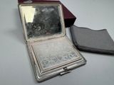a silver compact case with a mirror in it