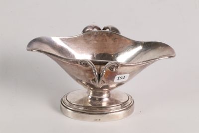 a small silver bowl on a pedestal on a white surface