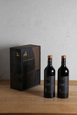 two bottles of wine sitting on a table next to a box
