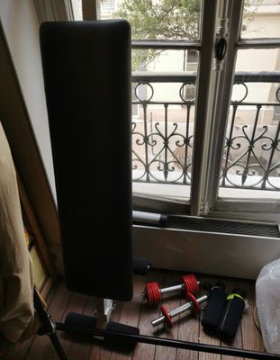 une enceinte noire posée par terre près d'une fenêtre