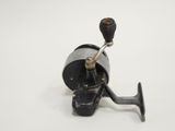 a close up of a fishing reel on a white surface