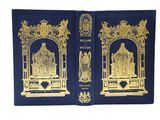 deux livres bleus ornés de motifs dorés, posés sur une surface blanche