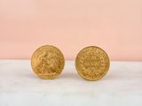 a pair of gold coins sitting on top of a marble counter
