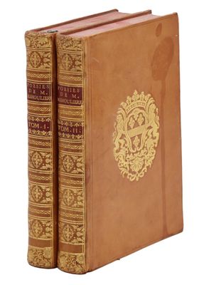 Ces deux livres sont de couleur marron et ornés de motifs dorés.