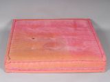 a pink box with a hole in it on a white surface