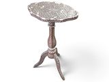 a silver metal table with a flower design on top of it