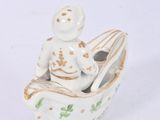 a figurine of a man in a boat on a white surface