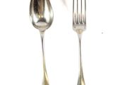 two silver spoons and a fork on a white surface