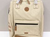 beige canvas backpack with tan leather trim and tan leather handles