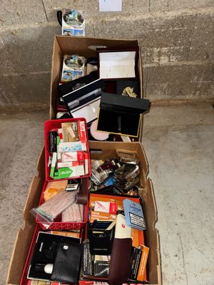 une boîte en carton posée par terre et remplie de toutes sortes d'objets