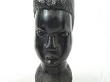 a black sculpture of a woman ' s head on a white background