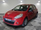 La petite voiture rouge est garée dans le garage, sur le sol à carreaux.