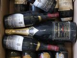 plusieurs bouteilles de vin dans un carton posé sur le sol