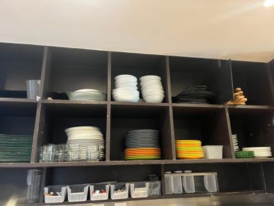 beaucoup d'assiettes et de bols sur les étagères de la cuisine