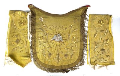 gold embroidered purse with a bird on it hanging on a wall
