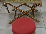 a small stool with a red cushion on it in a room