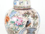 un vase sur lequel sont peints un oiseau et des fleurs