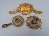 four pieces of gold and blue metal on a white surface