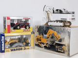 two boxes of toy construction vehicles on a white surface