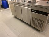 une cuisine en inox équipée d'un évier et d'un lave-vaisselle intégré au plan de travail