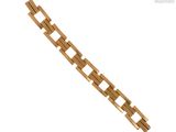 gros plan d'un bracelet en or sur fond blanc