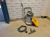 une photo représentant un aspirateur et un tuyau dans une pièce